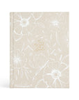 A hardcover journaling Bible with a beige background and floral designs, titled 'The Word of God' on the front cover.