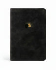 A black leather-like compact Bible with red letter text and a gold foil design on the cover, featuring a stylized sun and moon.