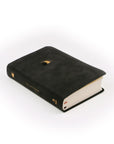 Black leather like Compact NLT bible laying at an angle.