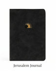 A black leather-like notebook with a gold-foiled illustration of Jesus's open tomb on the cover.