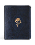 A navy blue notetaking Bible with a gold floral design on the cover, inspired by the Versailles Palace.