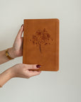 Amelia leather-like Christian journal with debossed wildflower design softcover notebook held in hands for prayer journaling and Bible study
