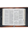 Faith honey brown faux leather Bible cover shown open with Bible inside, featuring organized interior, pen loops, and protective design for Christian Bible storage and daily use