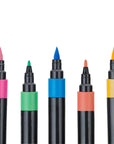 Close-up of Veritas Color acrylic paint markers showing pink, blue, and yellow brush tips and green and coral fine tips.
