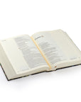 Open NLT journaling Bible from the Coram theme lying on a white background, showing the book of Psalms with wide margins for notes.