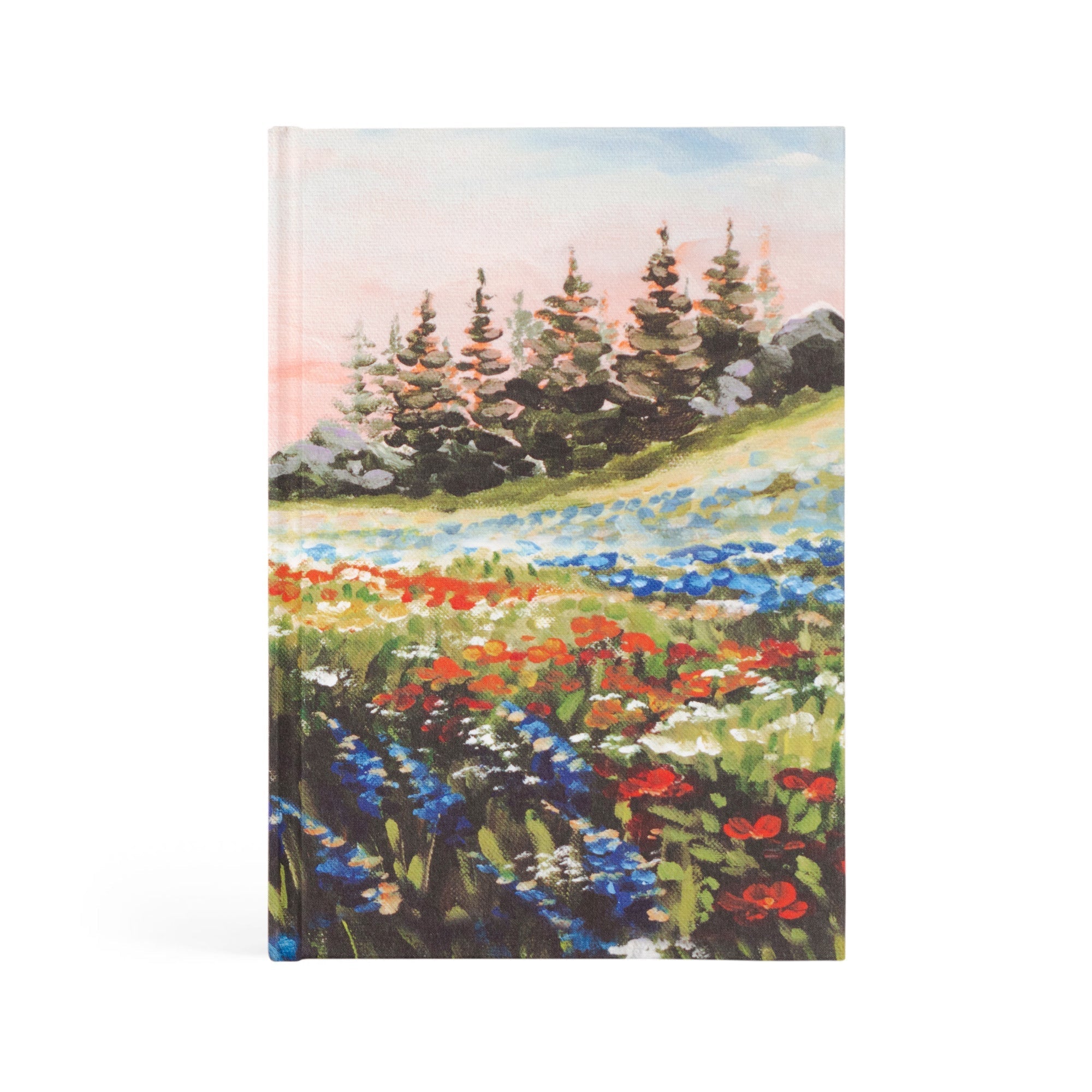 A hardcover prayer journal notebook with a hand-painted landscape of a meadow with colorful flowers and trees on the cover.