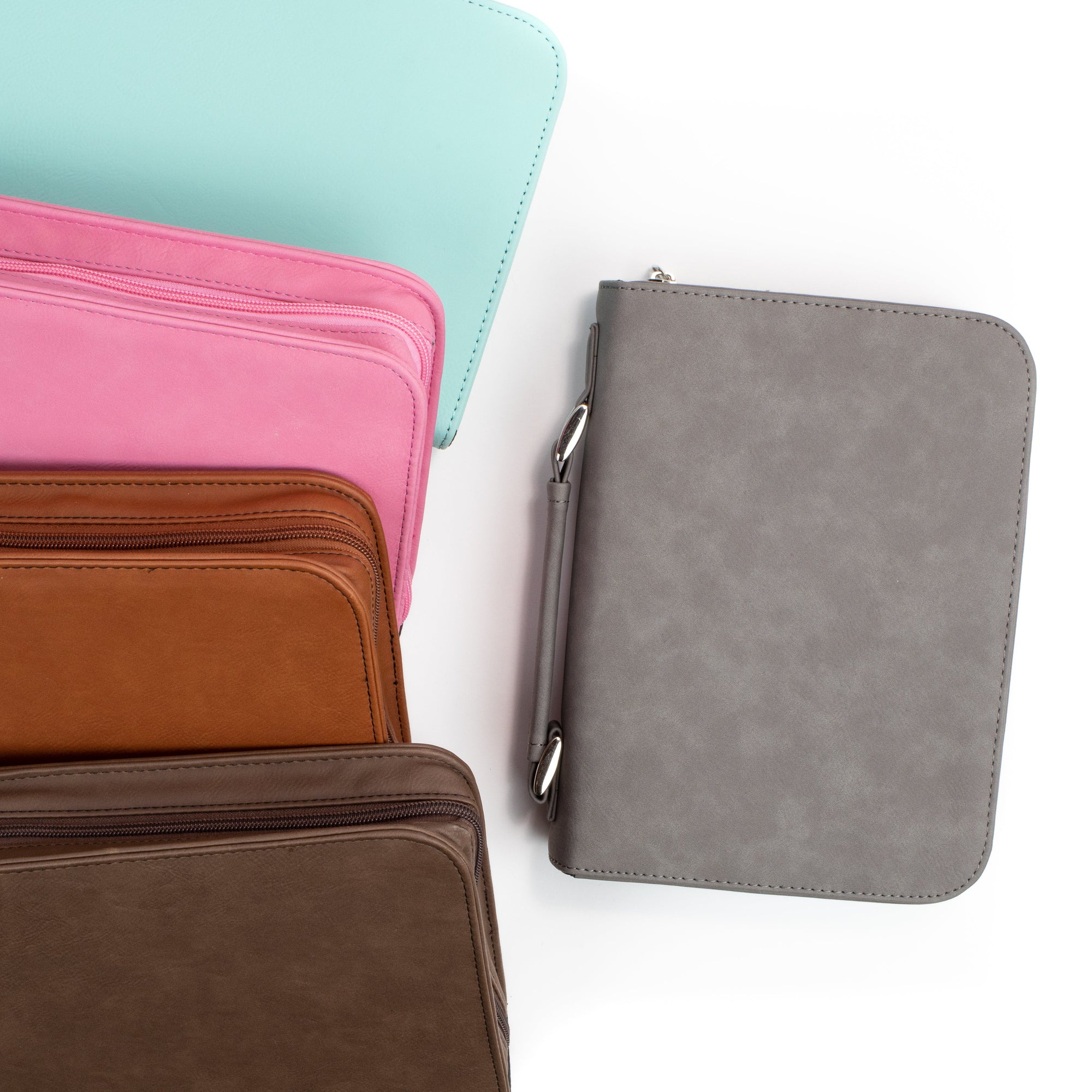 Four bible cover options in pink, brown, and gray on a white background
