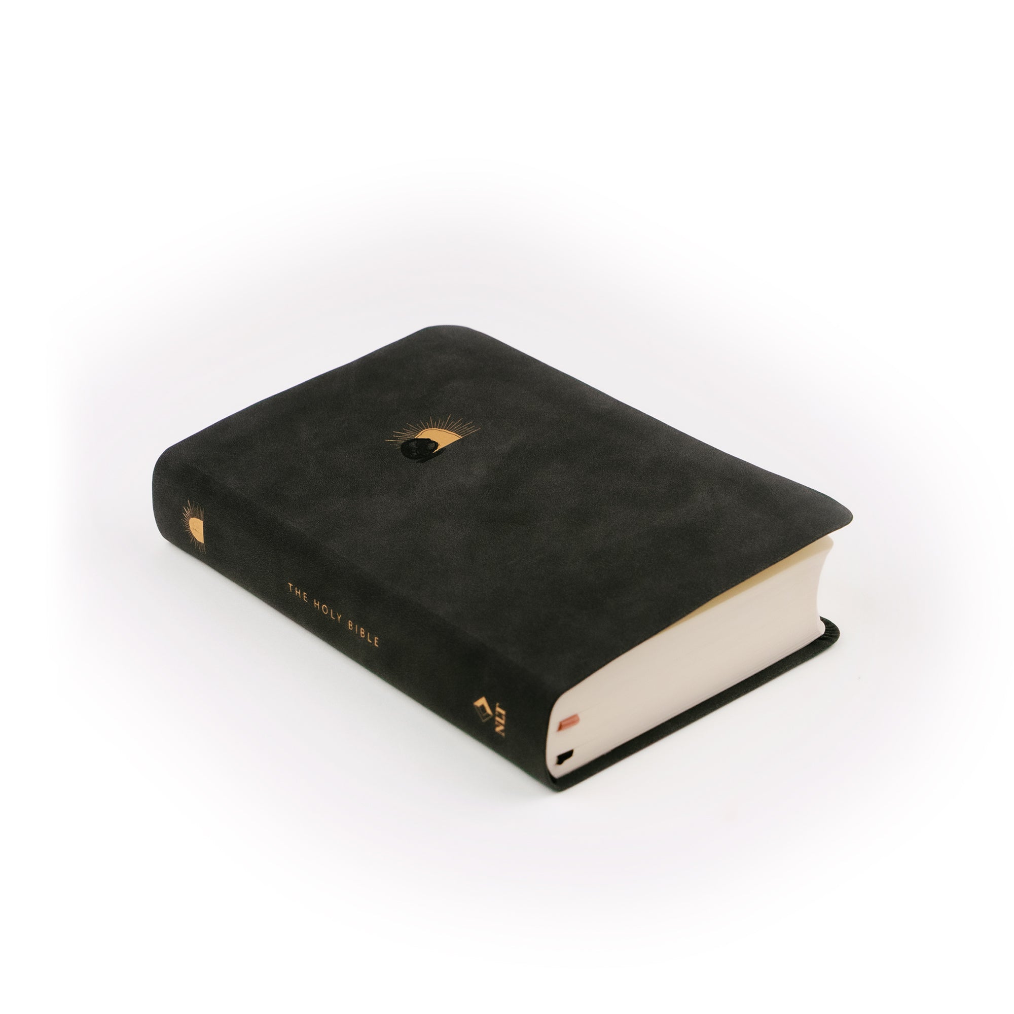 Black leather like Compact NLT bible laying at an angle. 