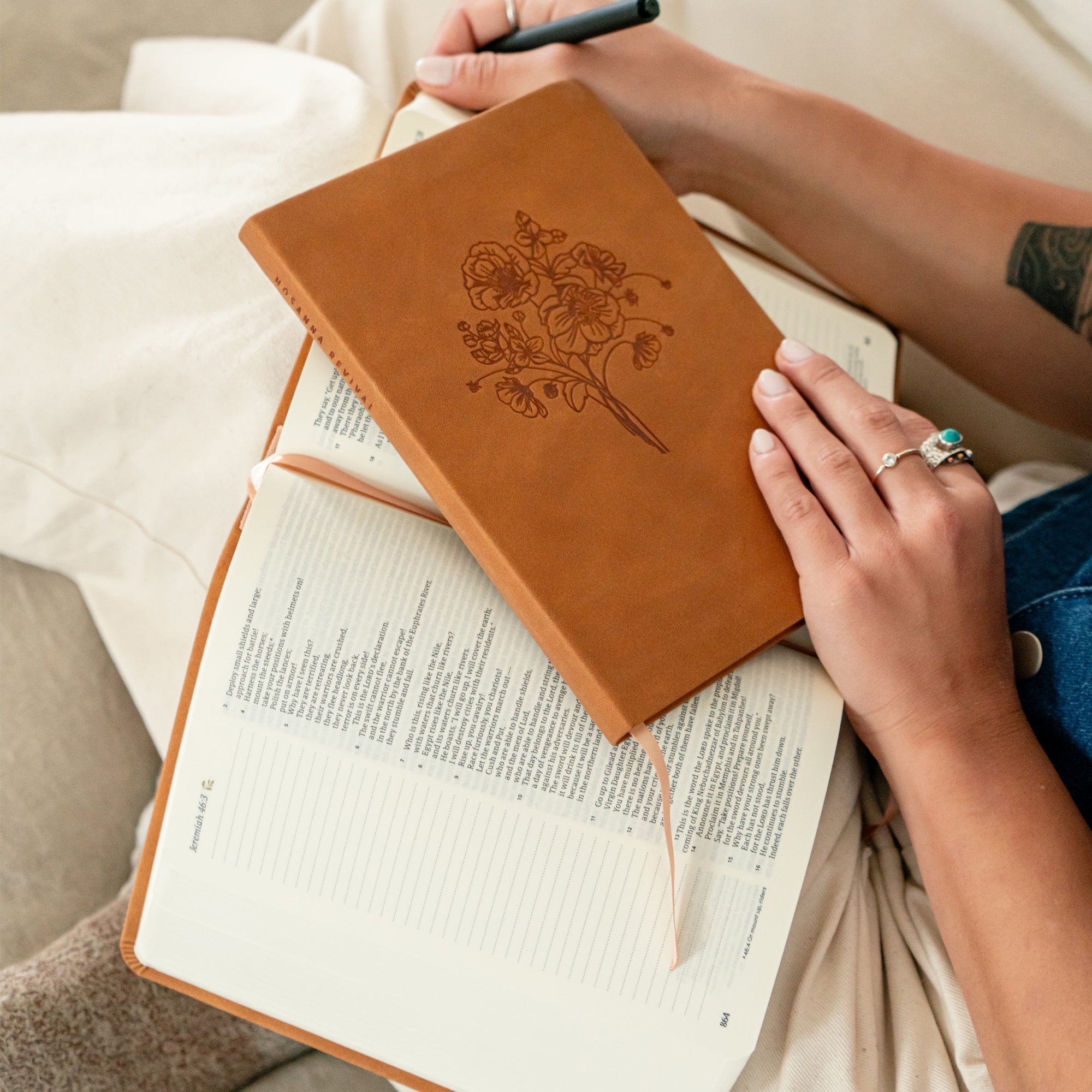 Amelia leather-like Christian journal with wildflower design resting on open Bible during quiet time prayer journaling and Scripture study