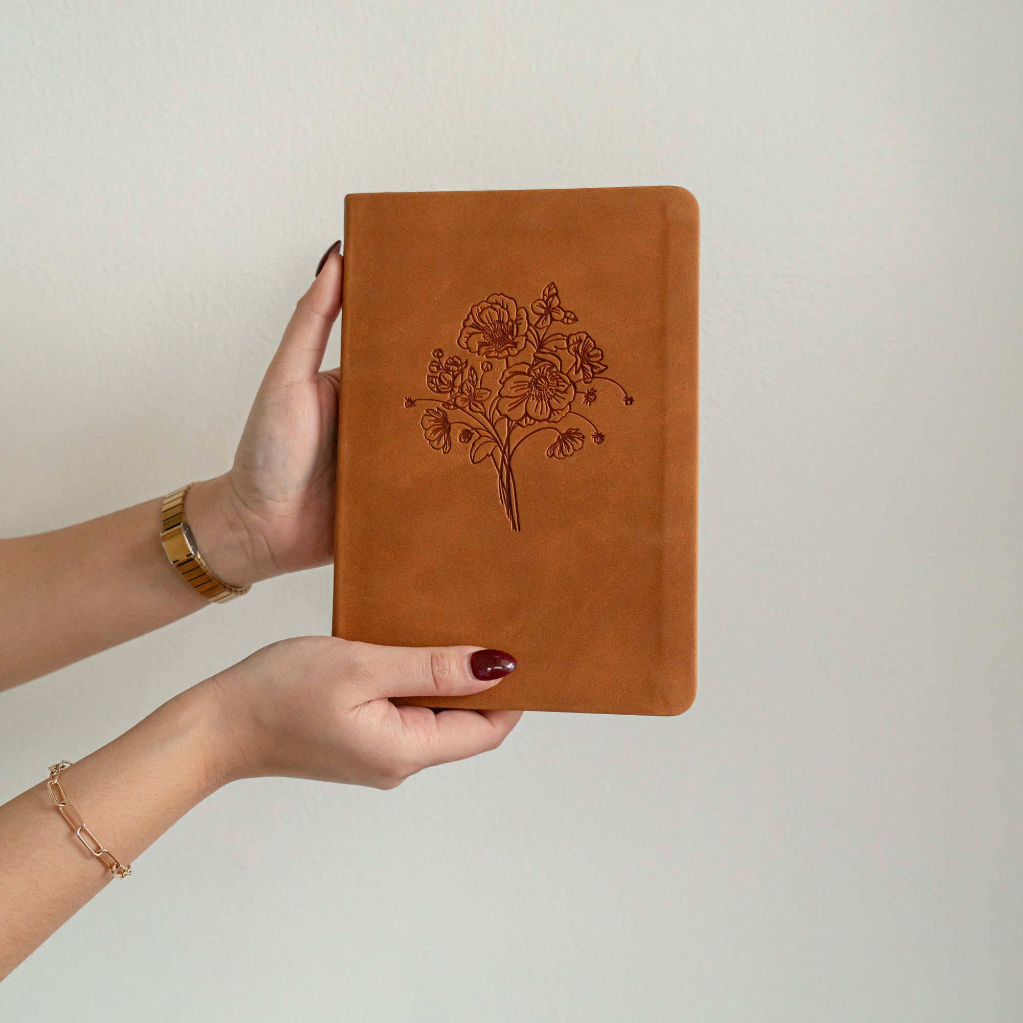 Amelia leather-like Christian journal with debossed wildflower design softcover notebook held in hands for prayer journaling and Bible study