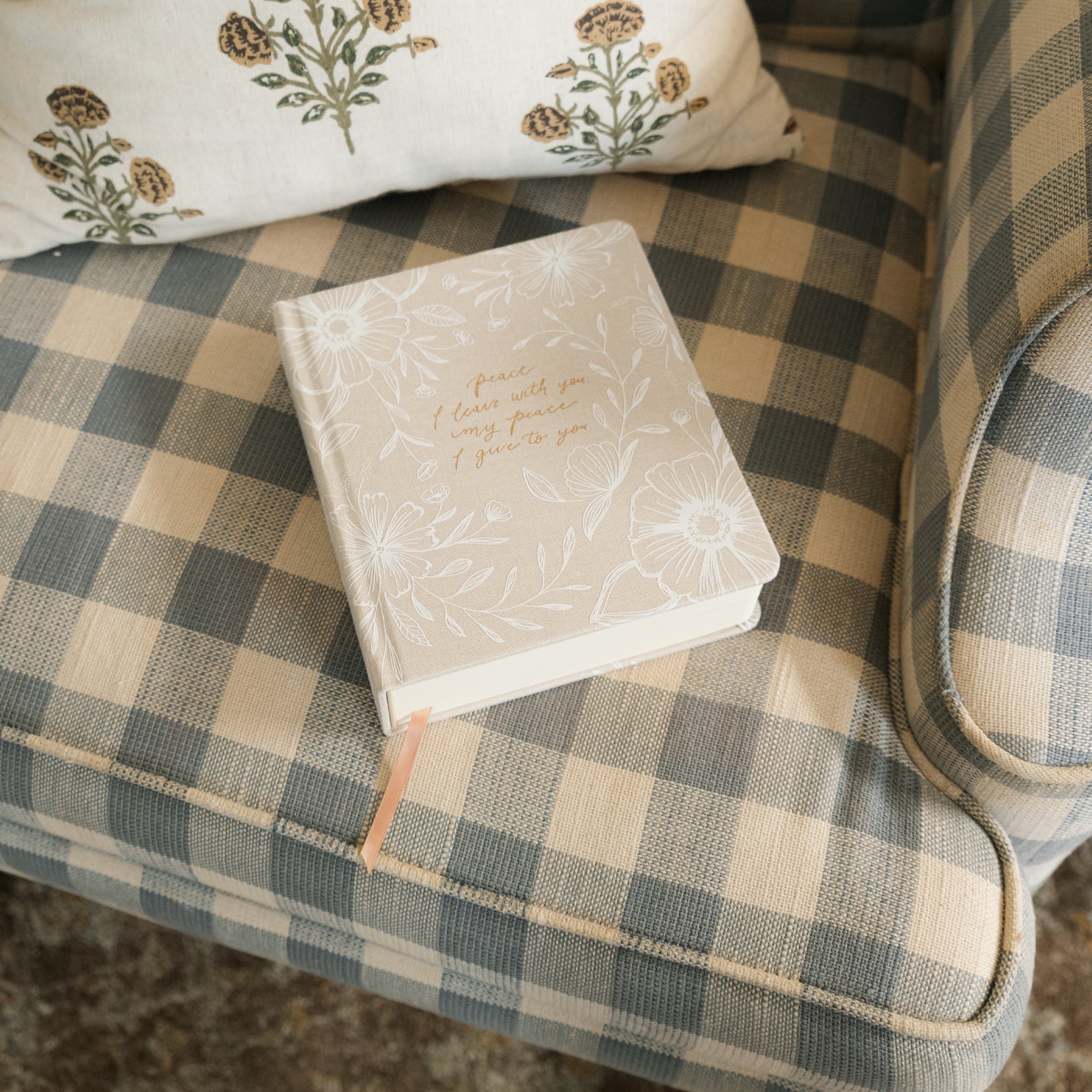 The Cordova 5 Year Prayer journal on a chair with ribbon/bookmarker extended. 