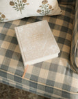 The Cordova 5 Year Prayer journal on a chair with ribbon/bookmarker extended. 