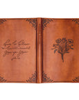 Vienna Christian notebook journal open flat showing floral bouquet design on front and John 1:16 Scripture on back warm brown leather-like cover for prayer journaling and Bible study