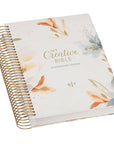 Pearlized white floral KJV spiral bound journaling Bible with faux leather cover and gold metal binding