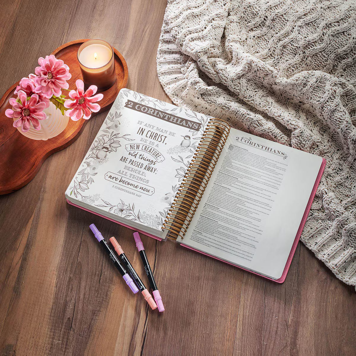 Open pink Creative Bible KJV Illustrators Edition showing illustrated Scripture page from 2 Corinthians with wide margins for journaling