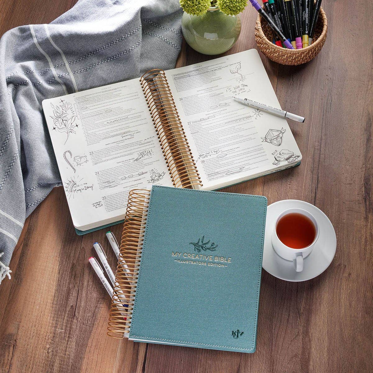 Teal spiral bound KJV journaling Bible laying flat with wide margins for notes, illustrations, and creative Bible study