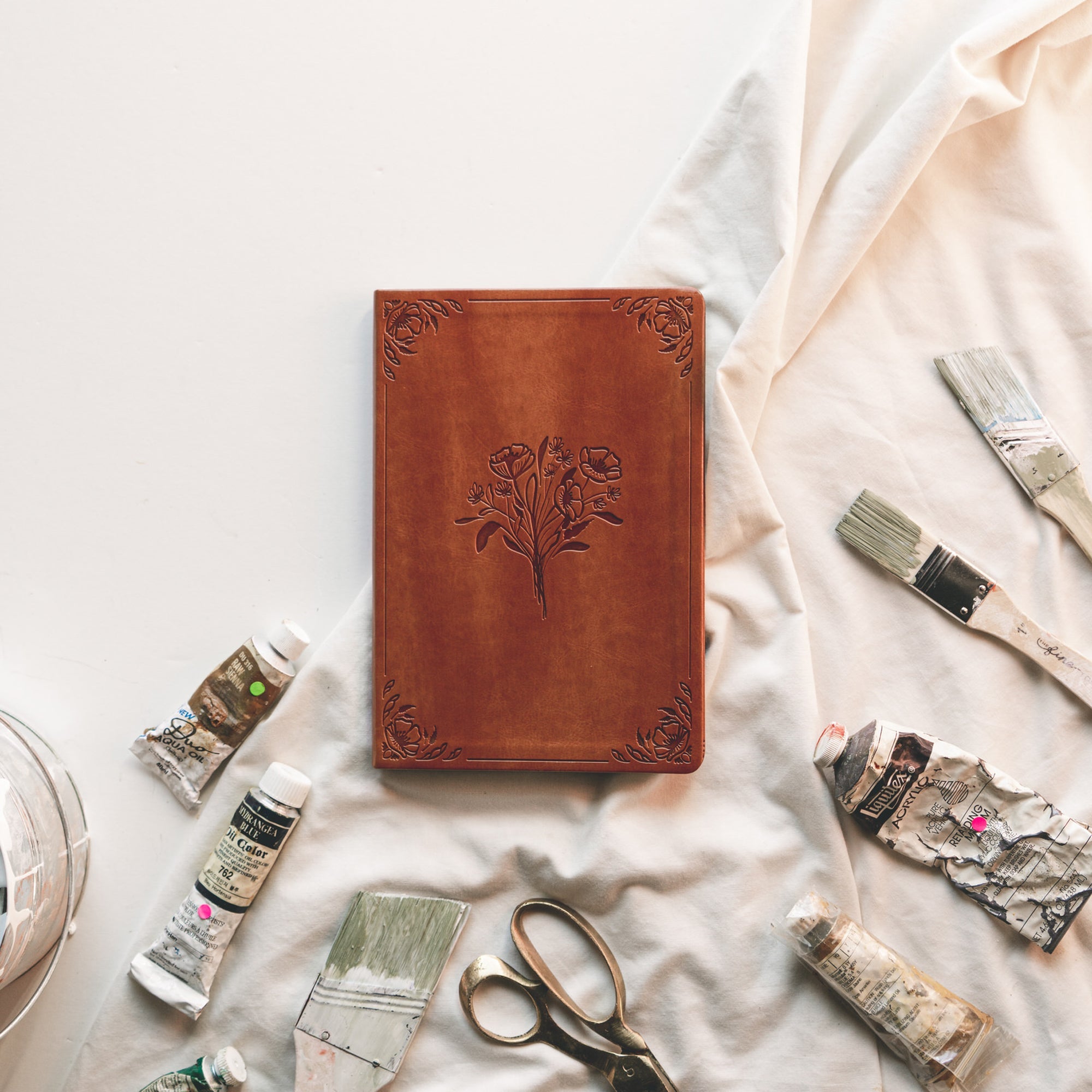 Vienna Christian notebook journal with floral design on warm brown leather-like cover styled in lifestyle setting for prayer journaling, Scripture reflection, and faith-inspired writing